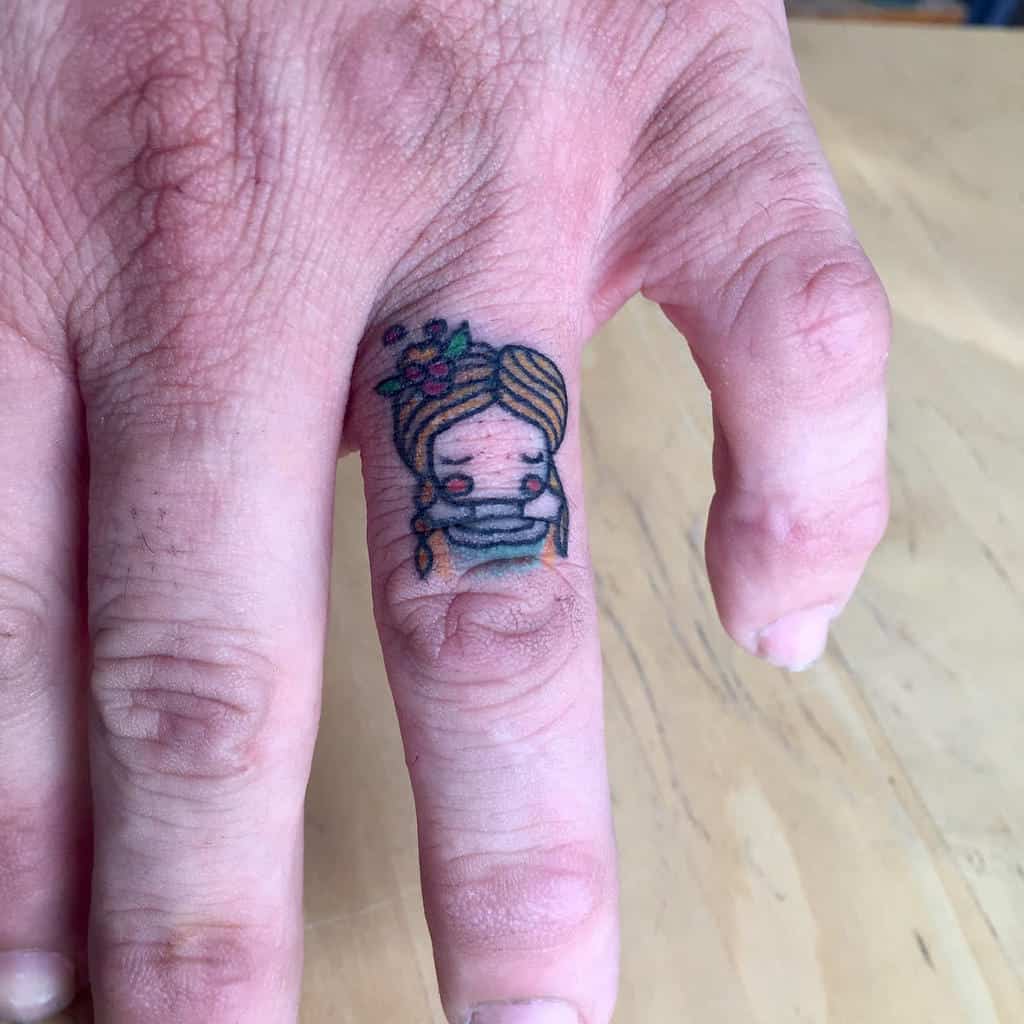 Tattoo of a cartoon woman with closed eyes and flowers in her hair