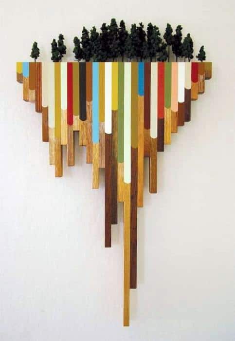 Colorful wooden wall art with vertical strips and a miniature forest on top.
