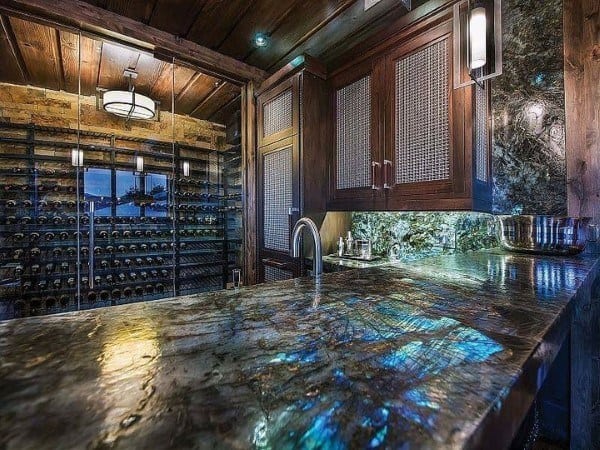 Luxurious bar featuring a colorful stone top with iridescent hues, complemented by wooden cabinetry and ambient lighting.