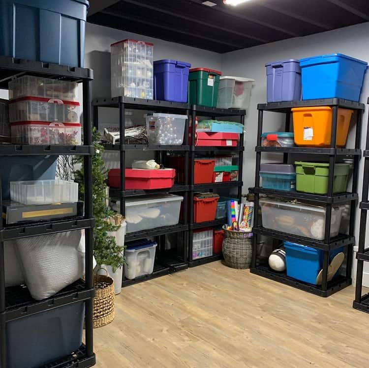 Basement storage shelves with colorful plastic bins and containers neatly organized for household items.