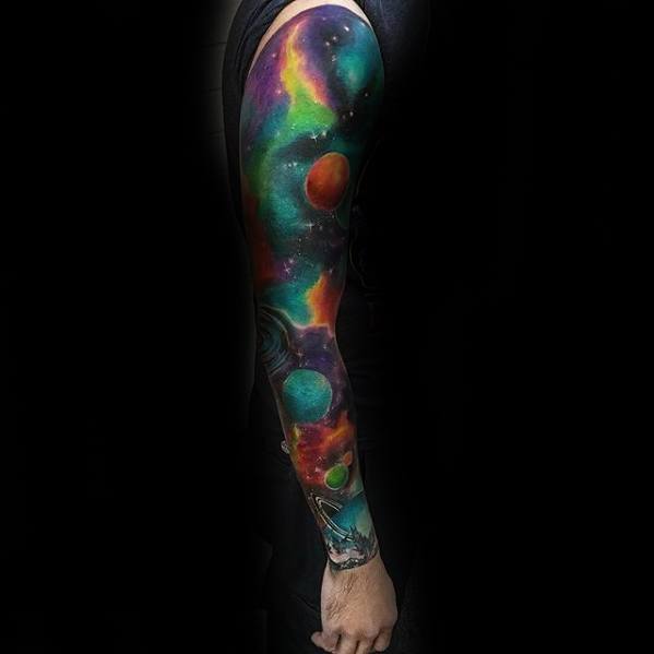 A person with a colorful nebula tattoo sleeve featuring planets and nebulae on their arm