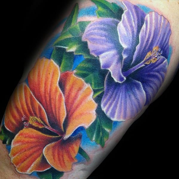 Colorful tattoo of orange and purple hibiscus flowers with green leaves on the skin