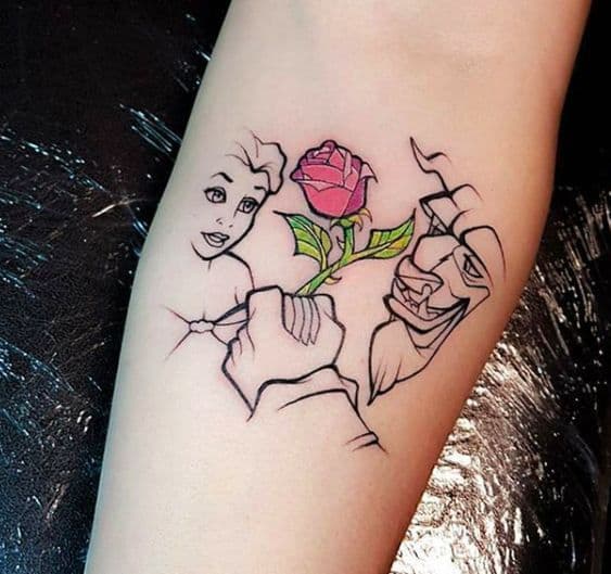 Minimalist tattoo of Belle and the Beast with fine-line details, featuring a vibrant red enchanted rose as the focal point.