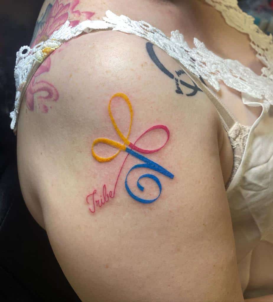 Colorful infinity symbol tattoo with "Tribe" text on shoulder