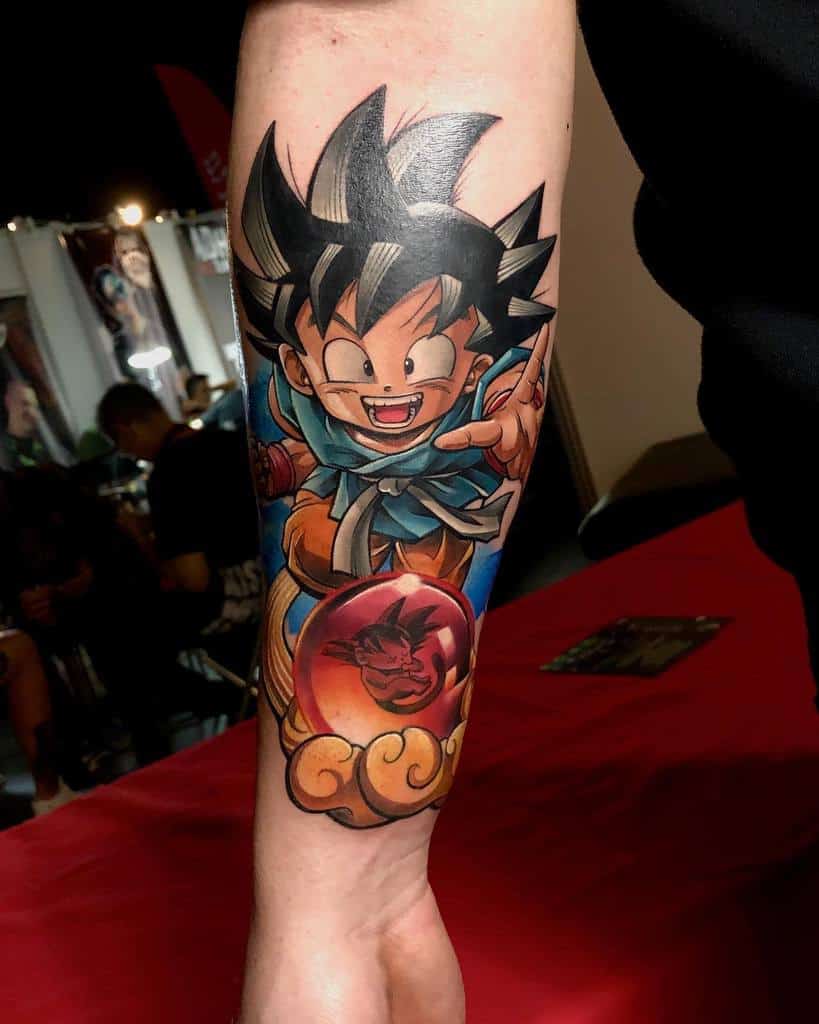 Vibrant Dragon Ball tattoo of young Goku with his Power Pole, standing on a golden cloud, featuring bold colors and detailed shading.