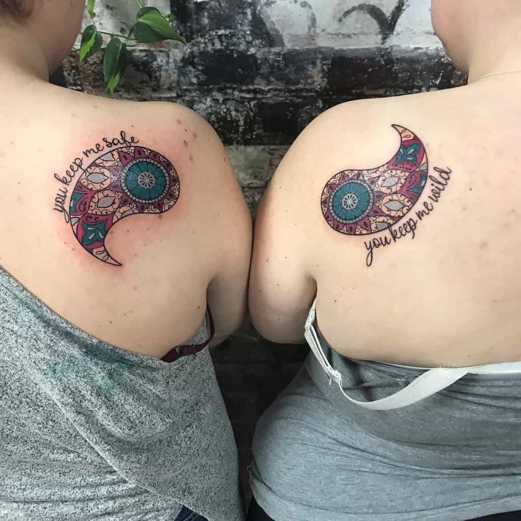Matching sister tattoos featuring a colorful paisley yin-yang design with the phrases 'You keep me safe' and 'You keep me wild.'