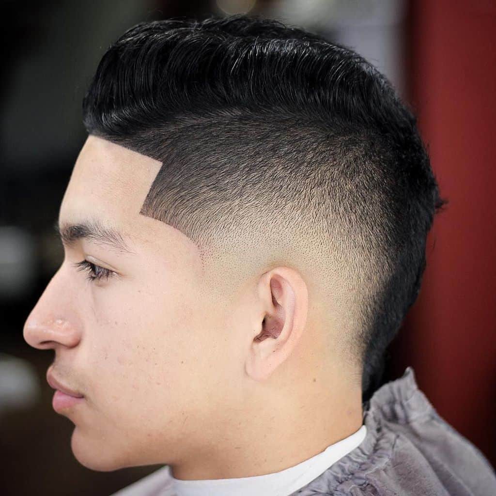 burst fade look with two hair lengths and a low fade. The top long hair is combed to the sides to create a comb-over look