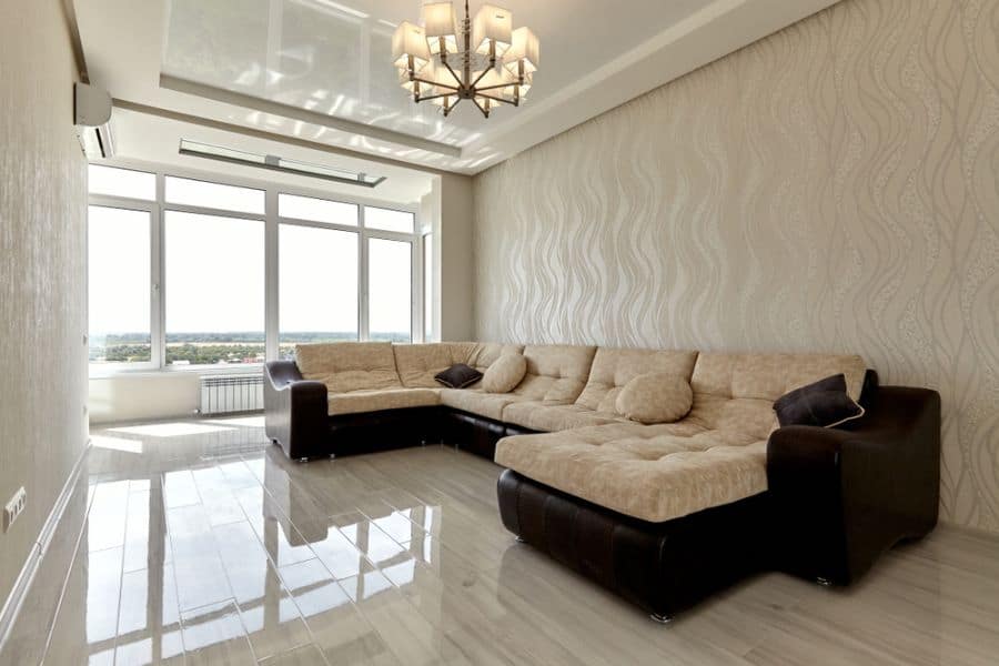 simple living room textured wall tile floor black and cream sectional sofa 