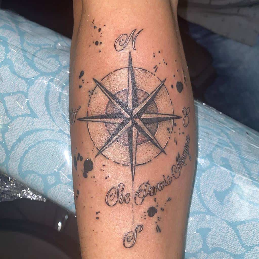 Compass tattoo with "Sic Parvis Magna" text and ink splatters on skin