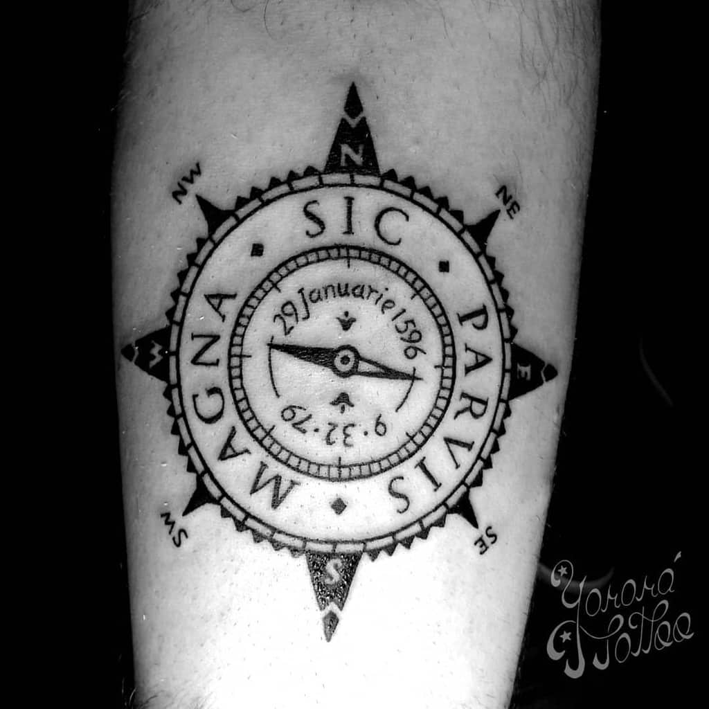 Tattoo of a compass with a date and coordinates in the center, adorned with Latin text "Sic Parvis Magna"