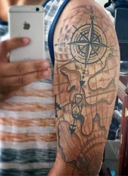 Arm tattoo of a detailed map with a compass