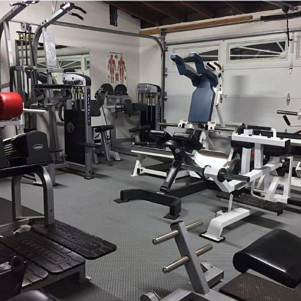 Garage gym fully equipped with weight machines, benches, and functional training equipment.