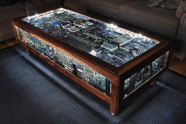 Coffee table made from illuminated computer circuit boards encased in glass, creating a tech-inspired design.