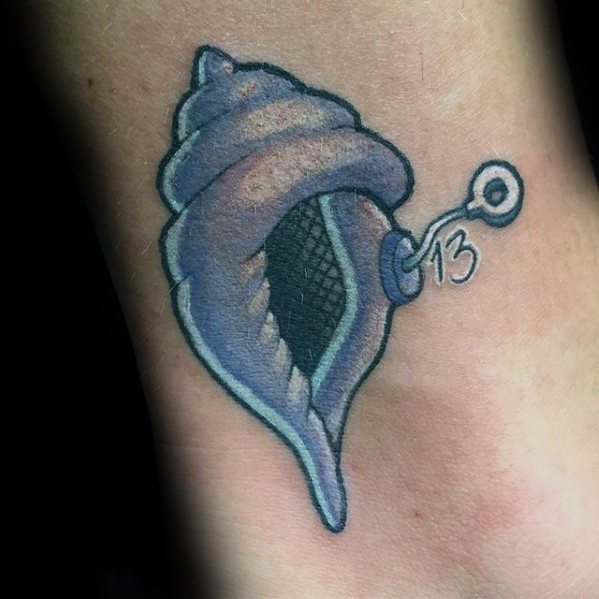 Tattoo of the Magic Conch Shell from SpongeBob, detailed in soft purple tones with a pull string and the number 13 attached.