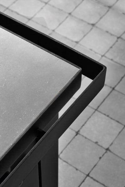 Sleek bar top featuring a combination of concrete and steel, showcasing a modern and minimalist design.