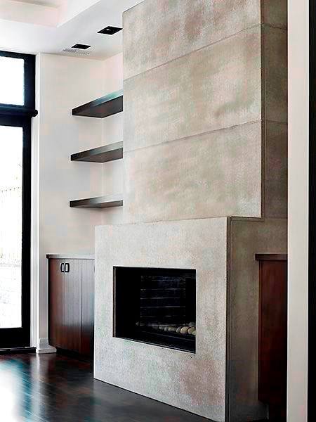 Modern concrete fireplace with built-in wood shelving and dark hardwood flooring.