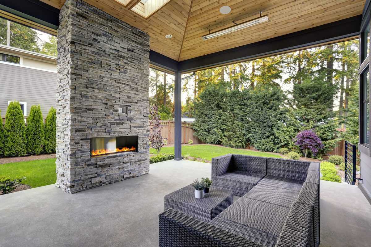 modern concrete patio stone fireplace wicker furniture
