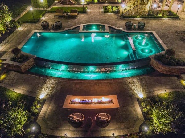 large pool backyard at night fire pit