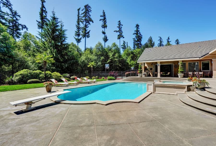 large concrete paver pool deck with diving board