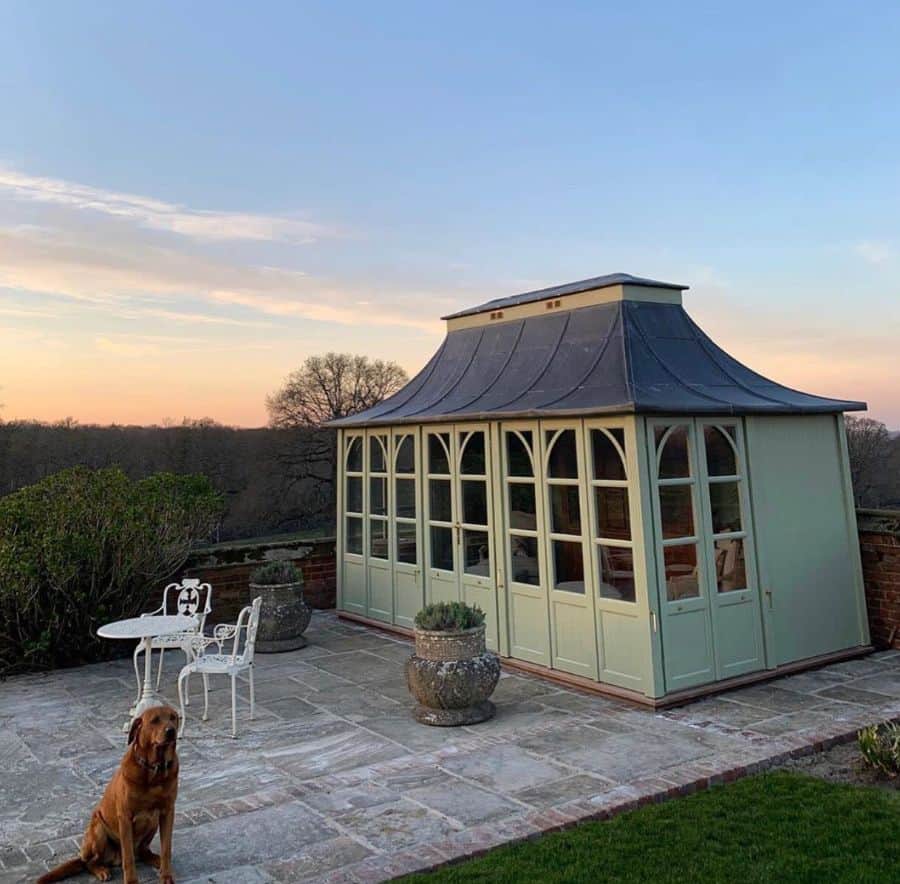 backyard green conservatory greenhouse paved stone patio