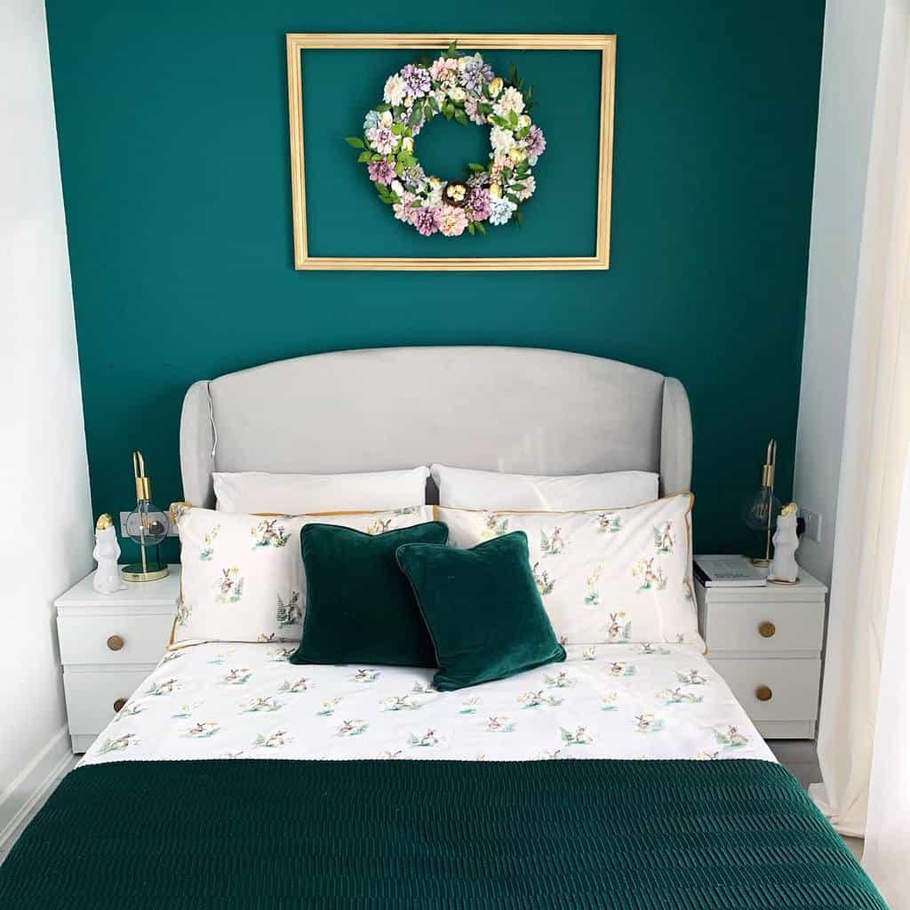Green-themed contemporary bedroom with upholstered bed, floral bedding, and wall wreath decor.