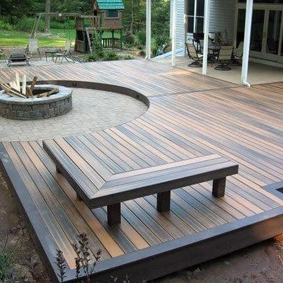 Wooden backyard deck with built-in bench and stone firepit area.