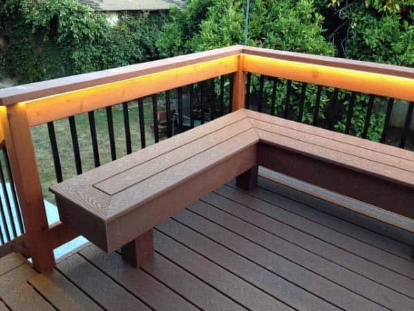 Wooden deck corner bench with built-in lighting, nestled among lush greenery