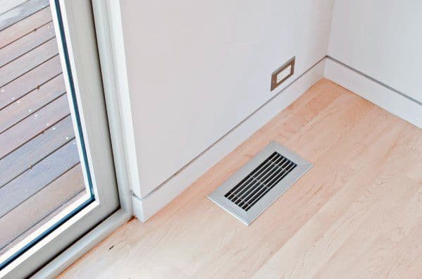 Minimal white baseboard with light wood flooring and a floor vent near sliding glass door.