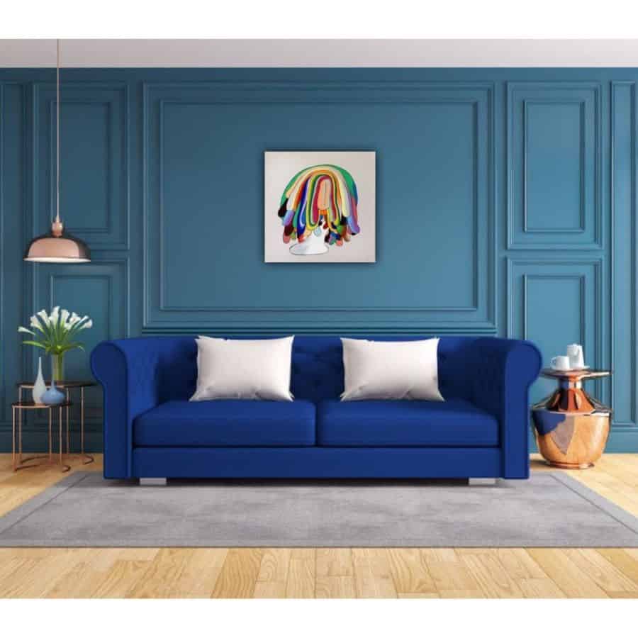 Modern living room with blue paneled walls, blue sofa, and colorful abstract wall art.