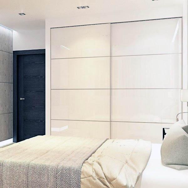 A sleek, modern bedroom with minimalist white sliding closet doors, offering a clean and spacious look for small spaces