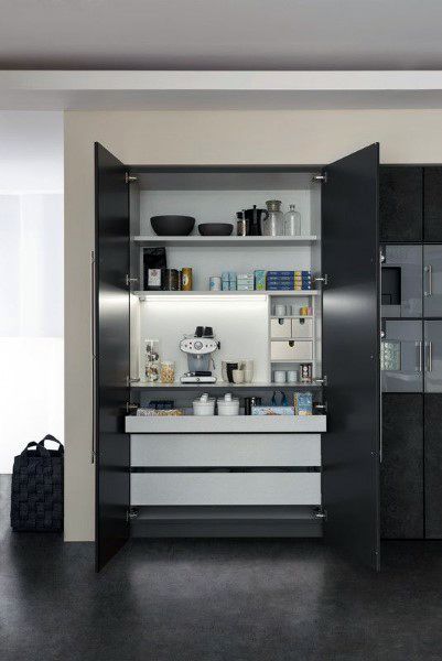 Sleek coffee bar with black cabinet doors, built-in shelves, and illuminated countertop space.