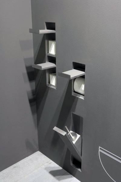 Modern minimalist bathroom with toilet paper holders and shelves built into the wall