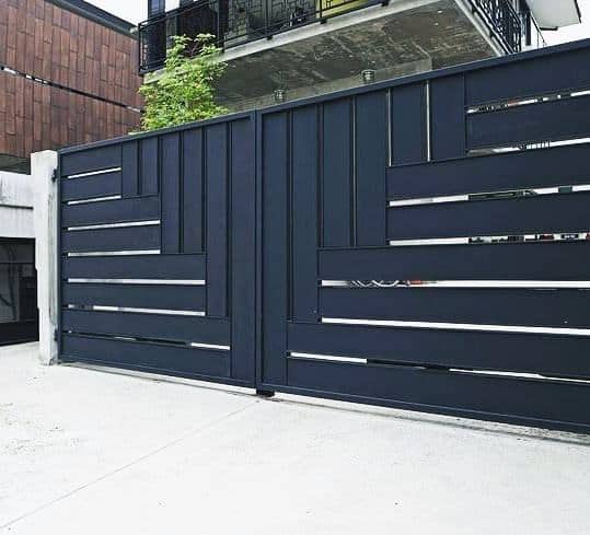 Contemporary black driveway gate with asymmetrical horizontal and vertical panel design.