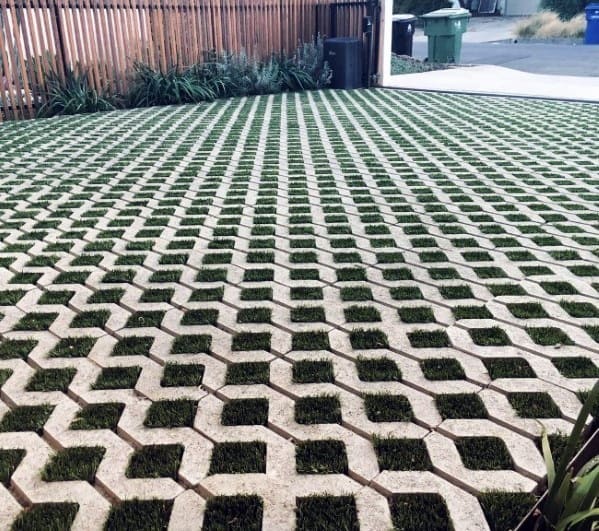 Permeable paver driveway with hexagonal concrete blocks and grass filling the gaps.