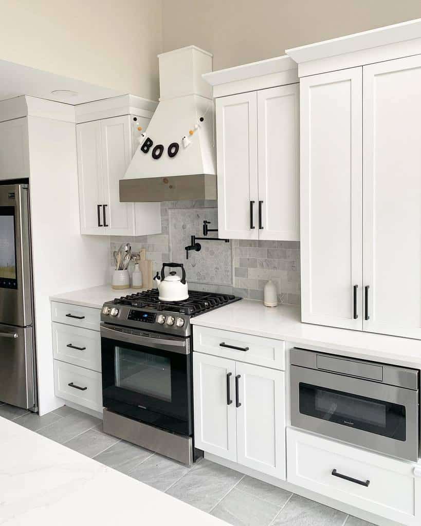 white galley kitchen with black accents modern appliances white kettle