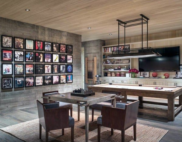 Stylish game room with a table, chairs, chessboard, pool table, TV, and wall of framed album covers