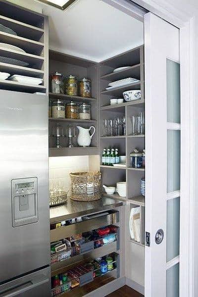 Compact pantry with sliding glass door, open shelves, and organized kitchenware.