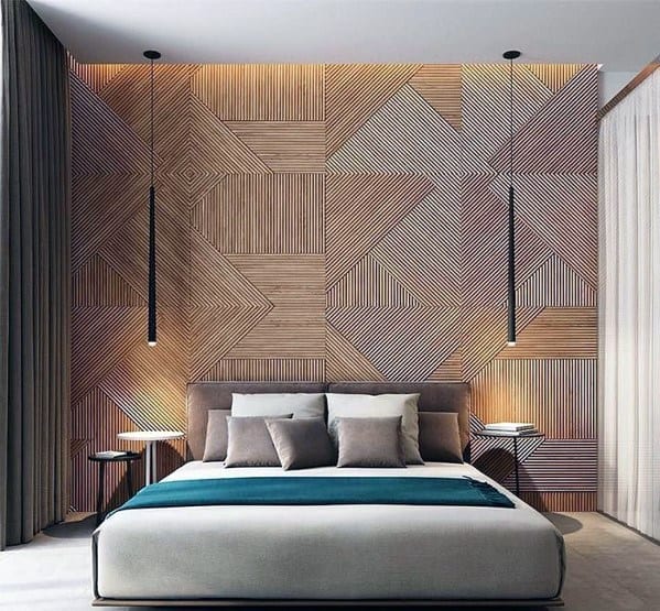 Modern bedroom with geometric feature wall, low-hanging black pendant lights, and cozy bedding.