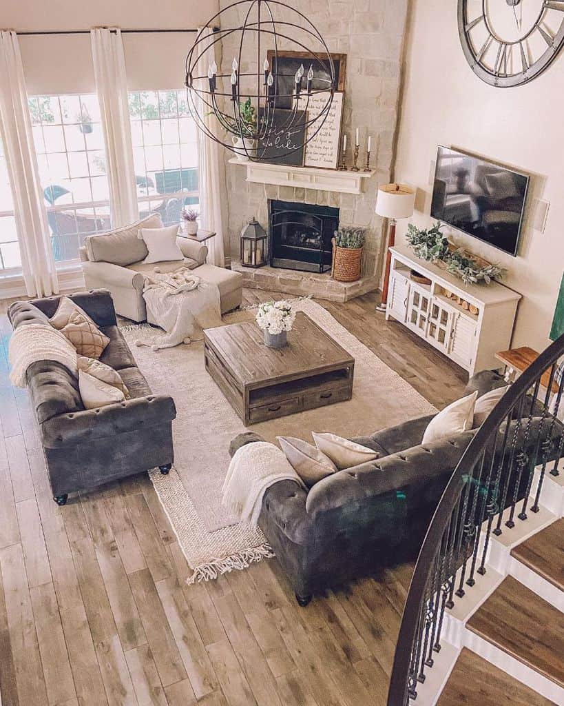 contemporary farmhouse living room stone fireplace wall mounted tv gray sofa white floor rug wood center table