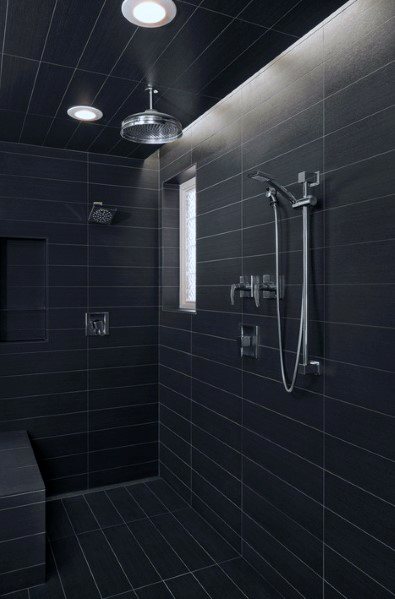 Modern shower featuring sleek black tiles, recessed ceiling lighting, and multiple shower fixtures for a luxurious experience