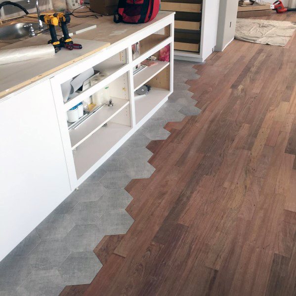 Modern tile-to-wood floor transition featuring hexagonal tiles blending seamlessly into warm wood planks for a unique finish