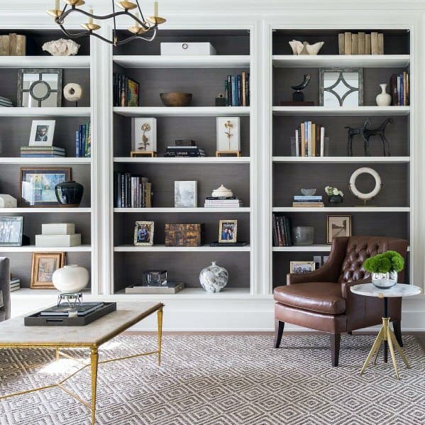 Cozy living room with a bookshelf, leather chair, and geometric-patterned rug
