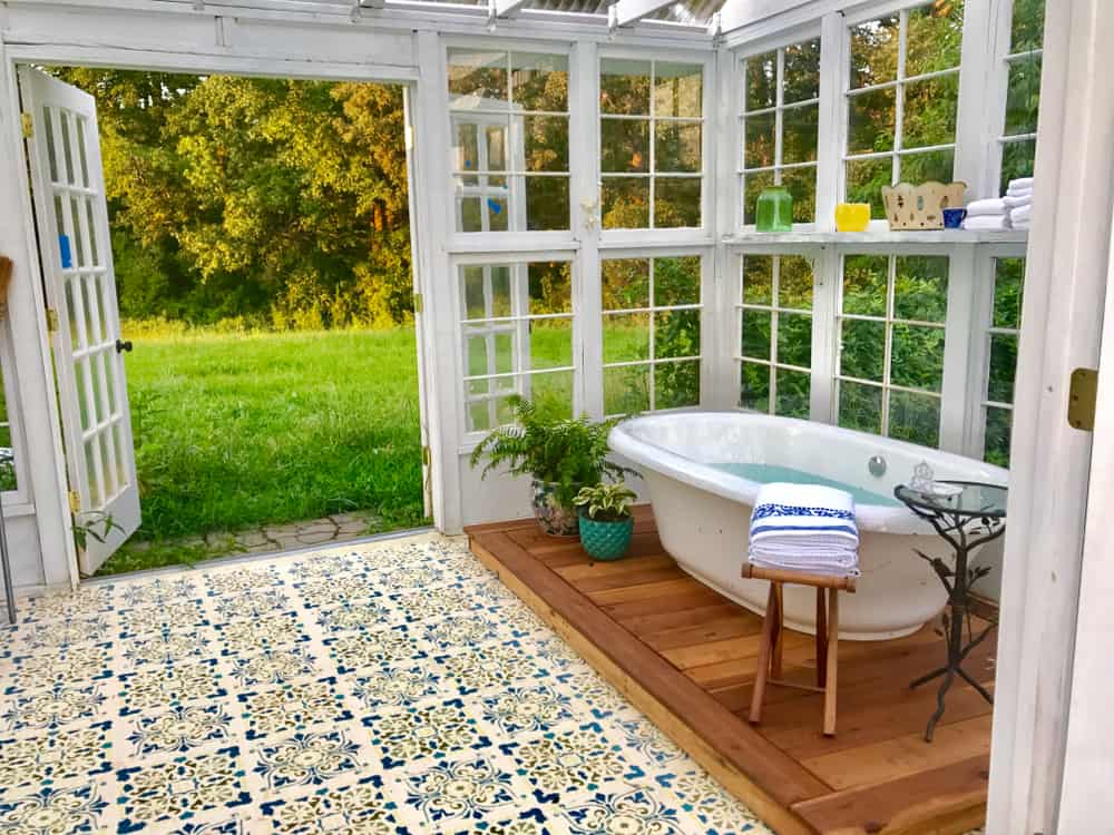 greenhouse with tile flooring and freestanding bath