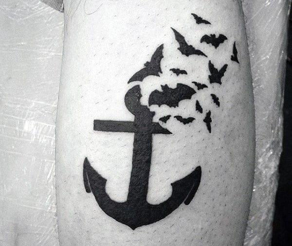 A tattoo of an anchor transitioning into flying birds on skin