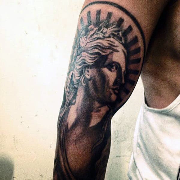 Tattoo of classical figure with a laurel, shaded in black and gray, on upper arm