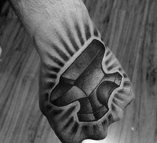 Realistic anvil tattoo on the hand with cracked texture and radiant shading lines extending outward for a bold, powerful effect.