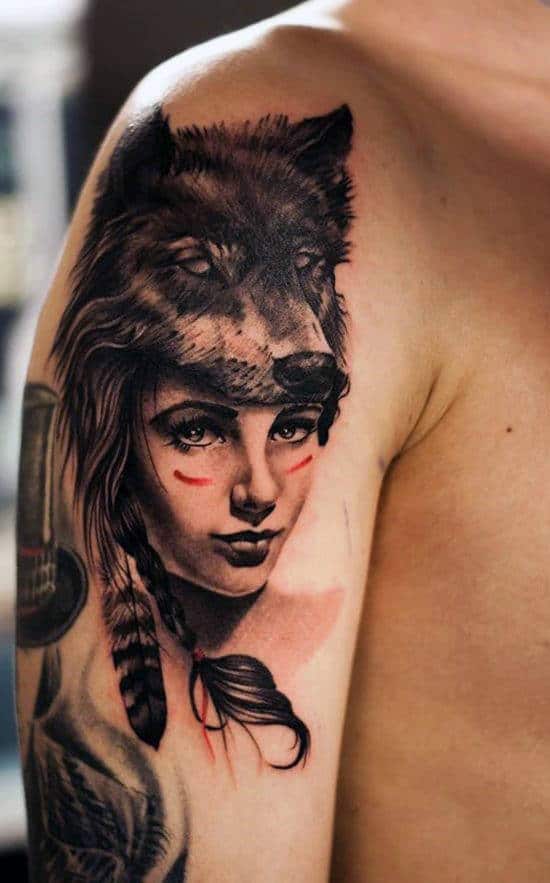 Tattoo of a woman's face with a wolf headdress on an upper arm
