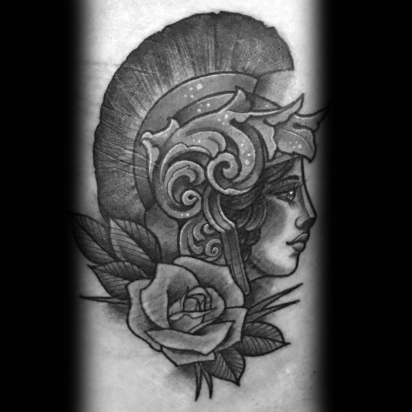 Traditional-style Athena tattoo with ornate helmet, defined profile, and rose with leaves in bold black and grey ink