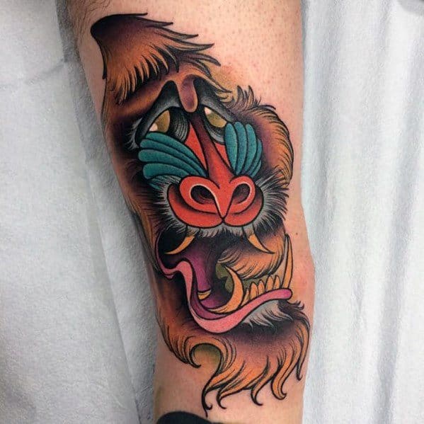 Neo-traditional baboon tattoo with bold outlines, vivid colors, and dynamic shading, featuring a fierce expression for a striking forearm design.