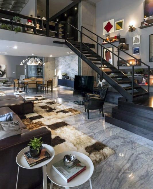 Spacious living room with marble flooring, modern staircase, and stylish decor accents.